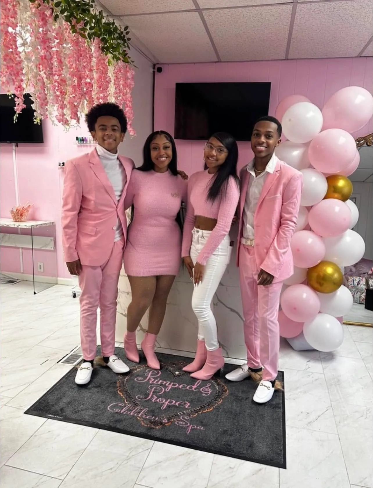 The team in pink standing with balloons and gold accents