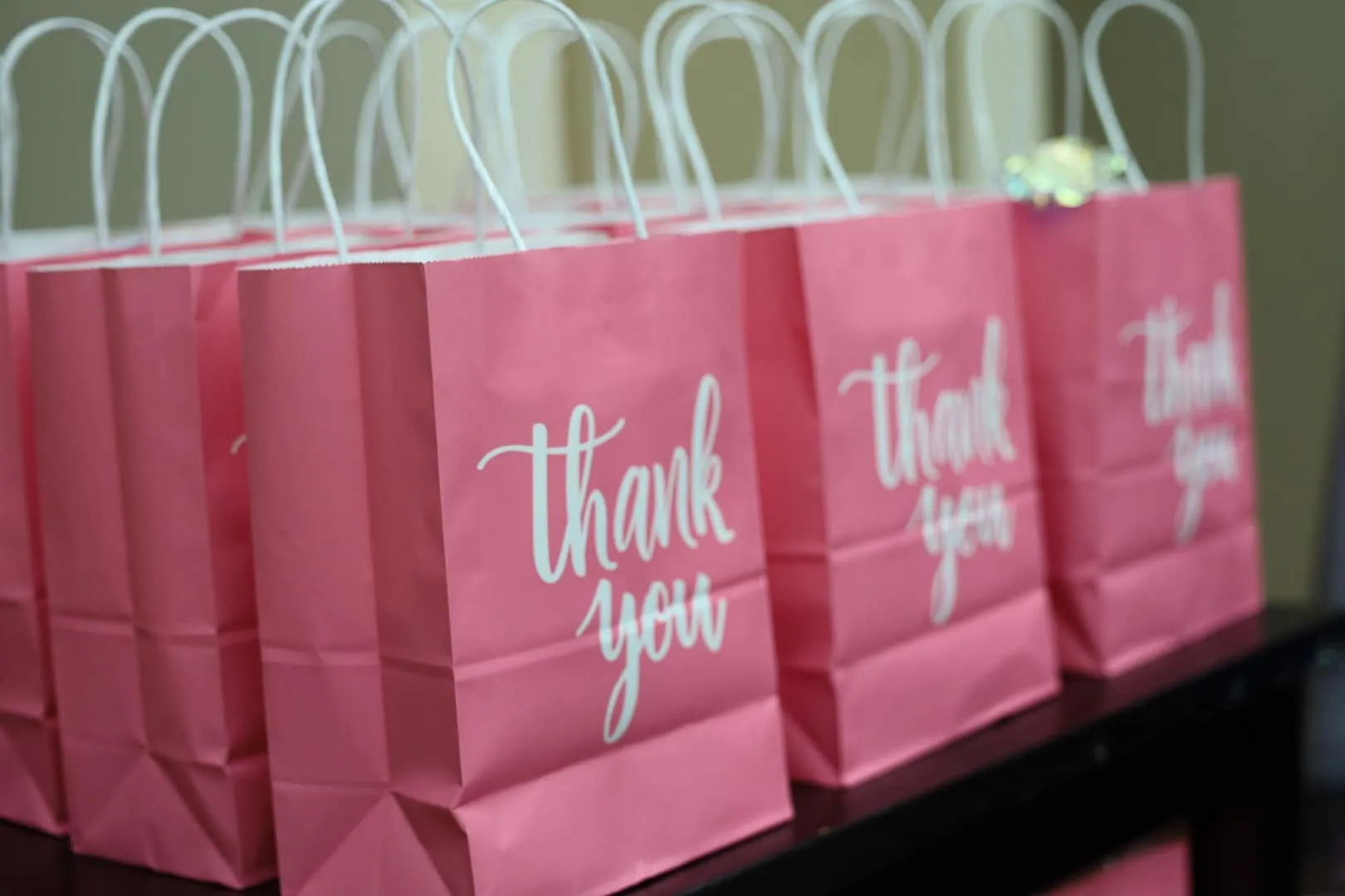 Pink thank you bags stacked and ready for guests